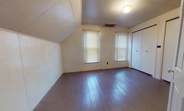a view of a livingroom with wooden floor and window