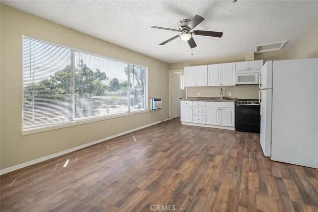 a open kitchen with wooden floor and stainless steel appliances