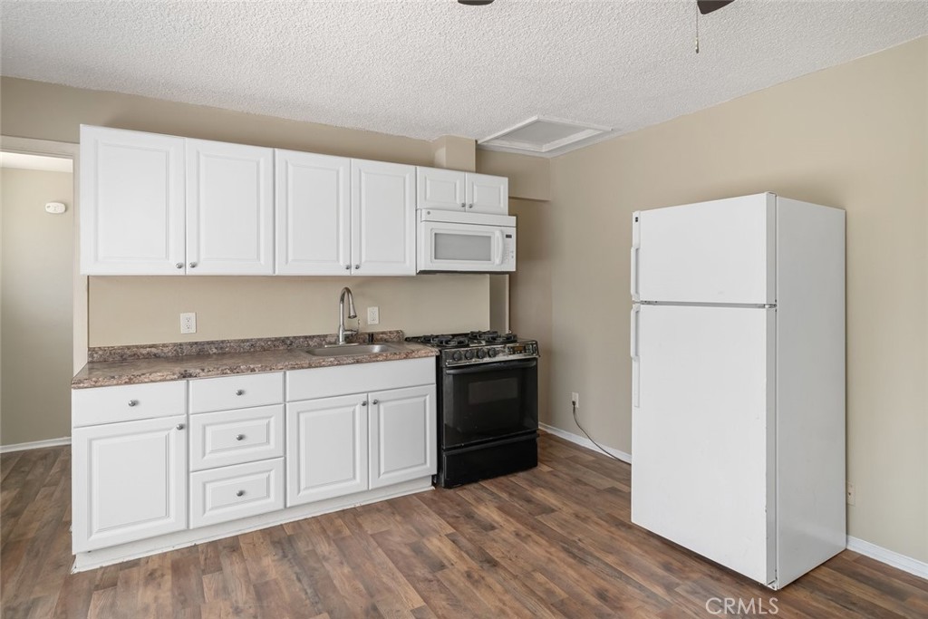 3505 Spring Street Paso Robles, CA 93446 - Photo 6 of 19 a kitchen with granite countertop white cabinets and refrigerator