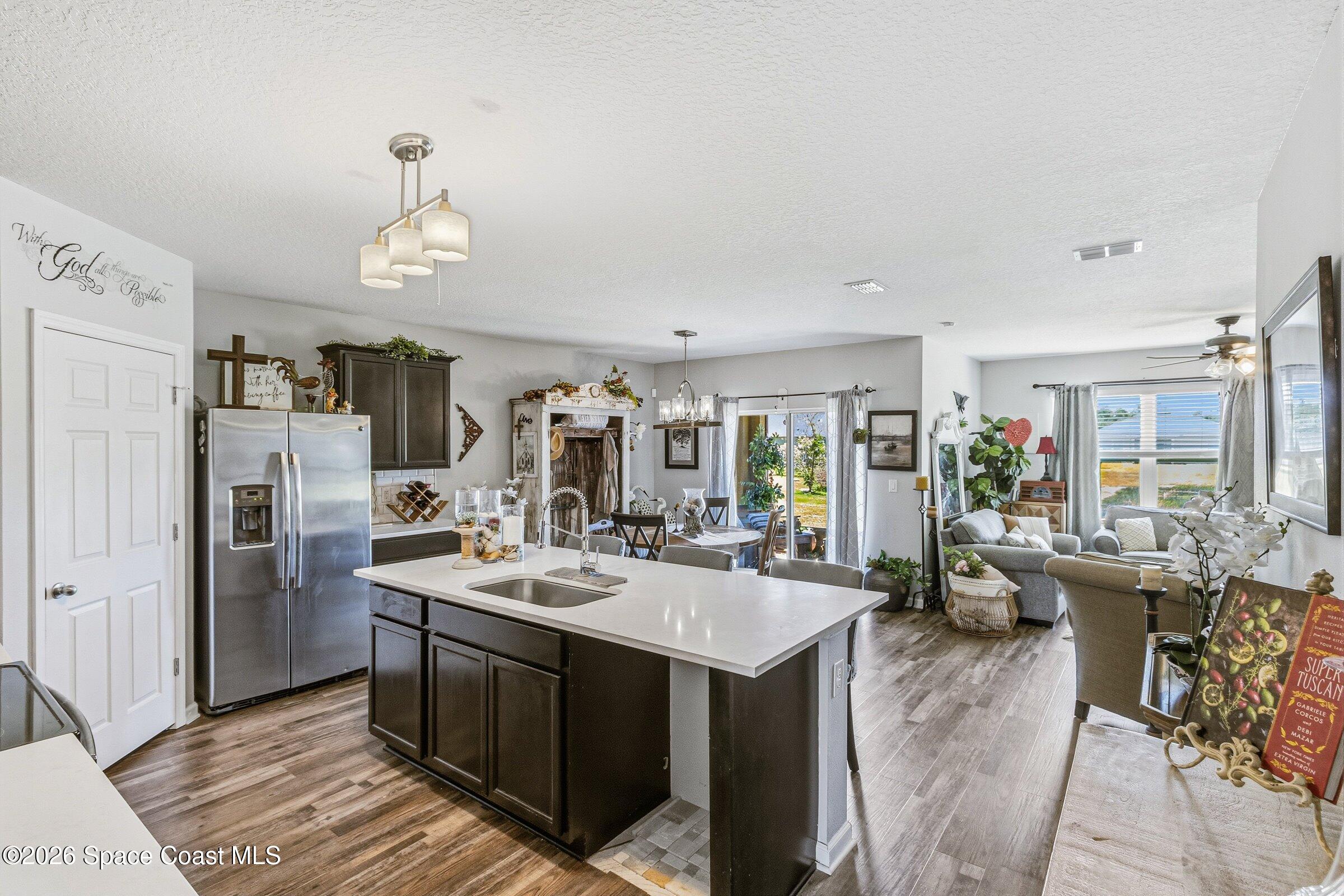 2213 McCormack Way Melbourne, FL 32935 - Photo 11 of 73 a large kitchen with a counter space a sink appliances and living room view