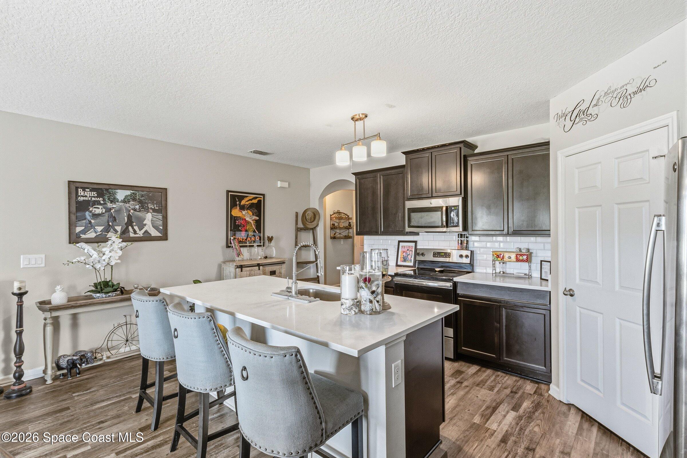 2213 McCormack Way Melbourne, FL 32935 - Photo 12 of 73 a kitchen with kitchen island a sink stove and refrigerator