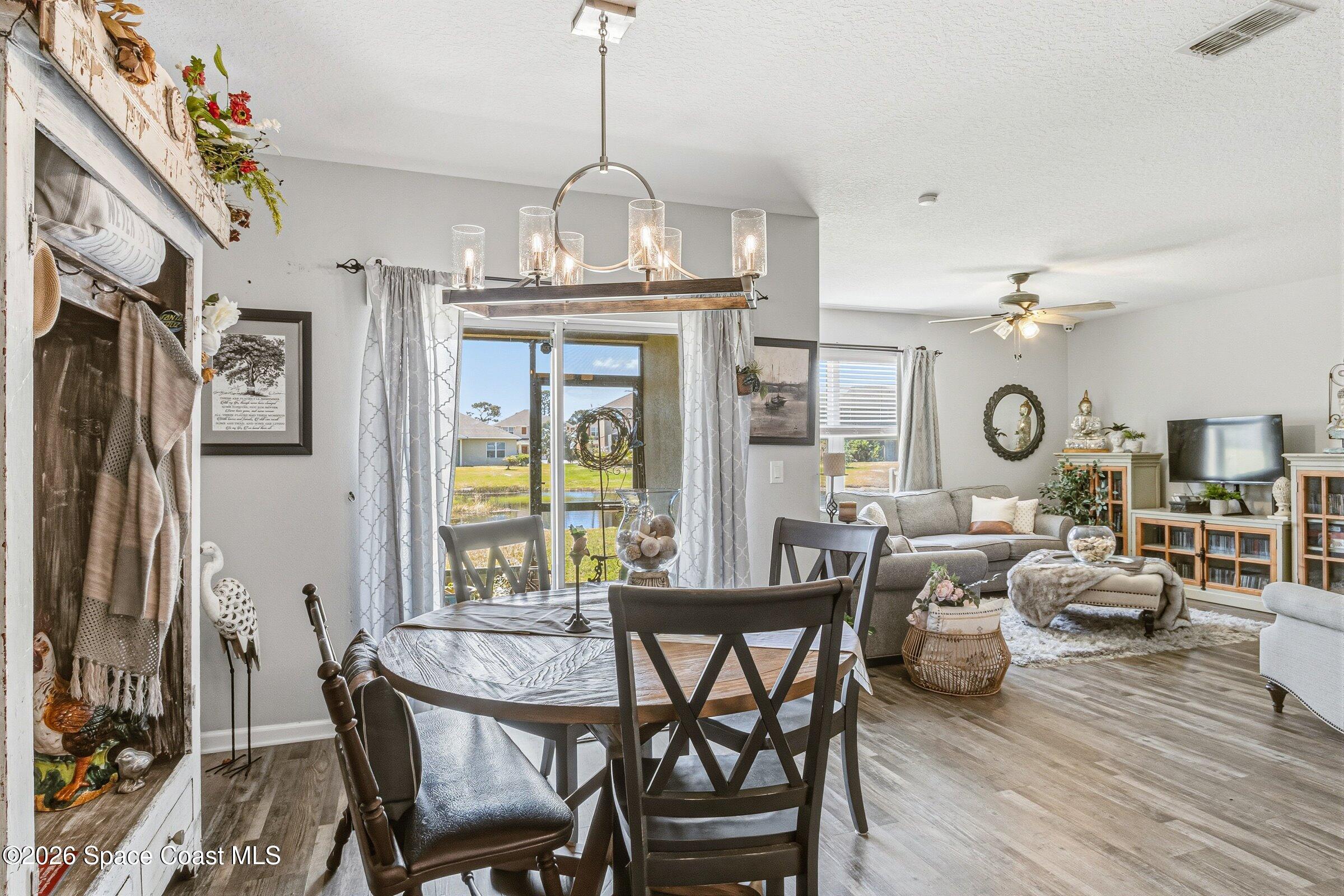 2213 McCormack Way Melbourne, FL 32935 - Photo 20 of 73 a view of a dining room with furniture a chandelier and wooden floor