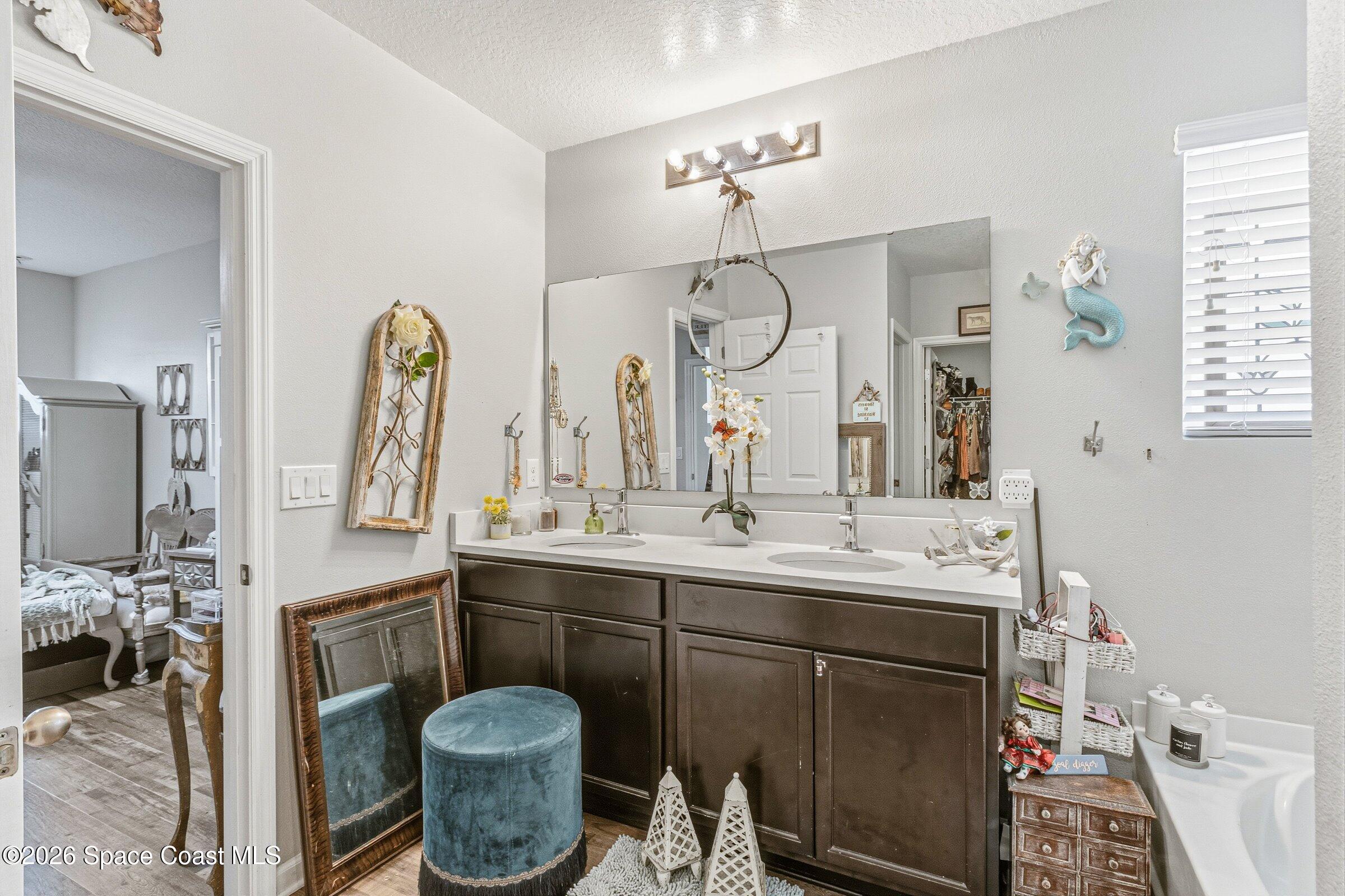 2213 McCormack Way Melbourne, FL 32935 - Photo 26 of 73 a bathroom with a double vanity sink and a mirror