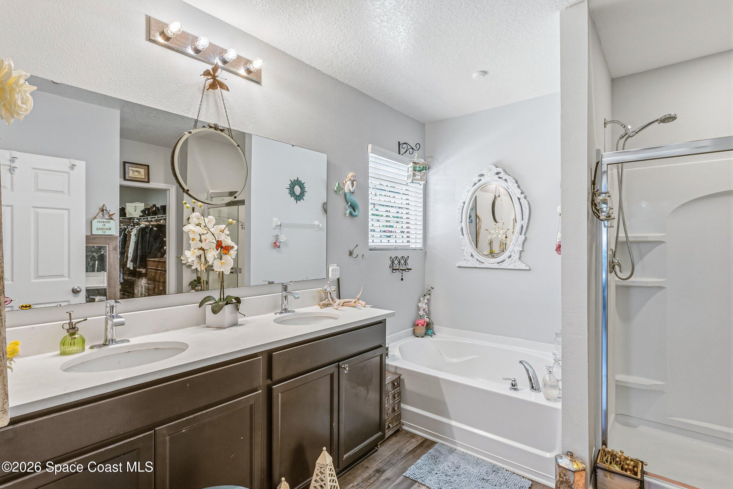 2213 McCormack Way Melbourne, FL 32935 - Photo 28 of 73 a bathroom with a bathtub a double vanity sink and a mirror
