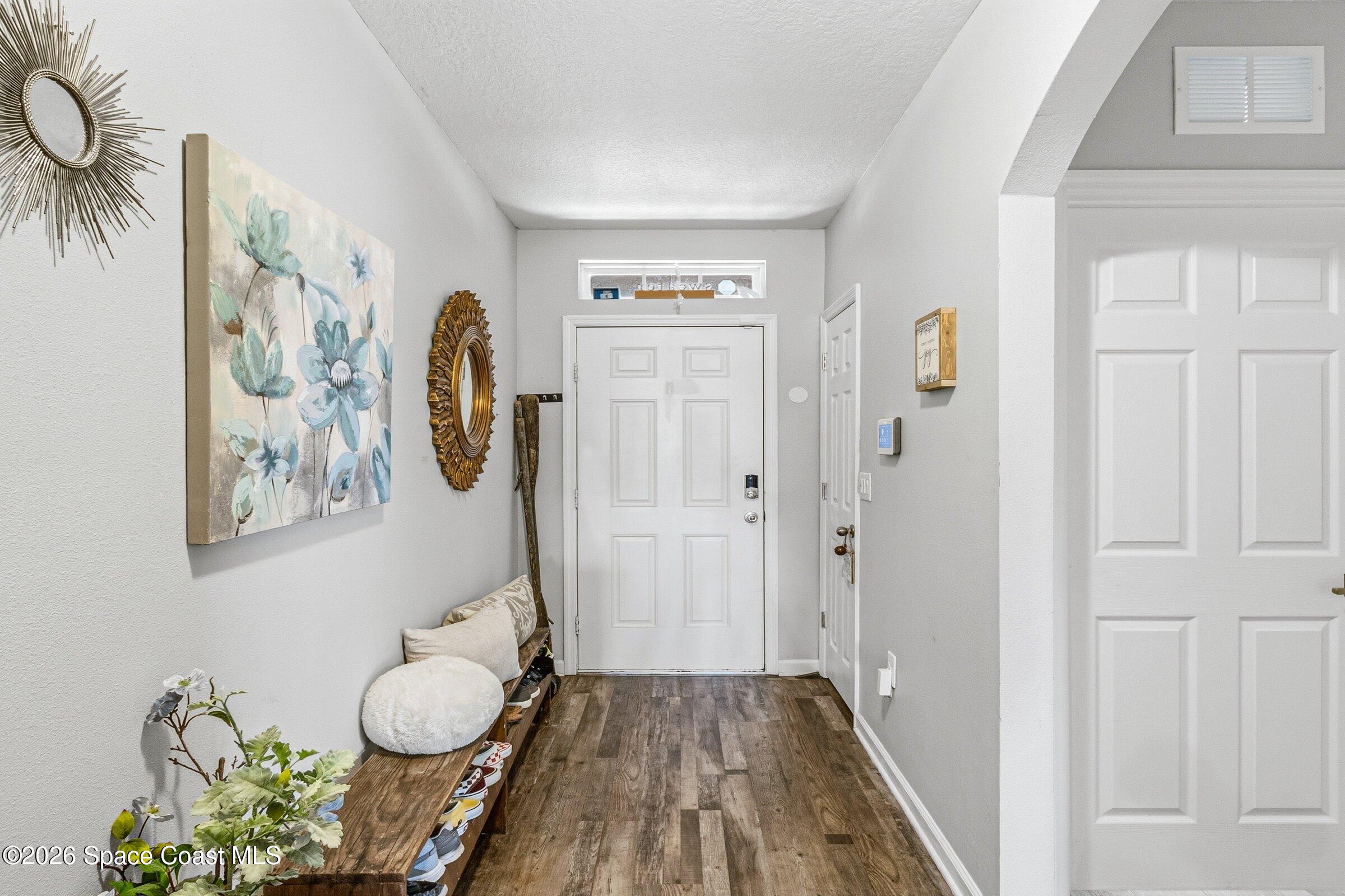 2213 McCormack Way Melbourne, FL 32935 - Photo 29 of 73 a view of a hallway with wooden floor and furniture