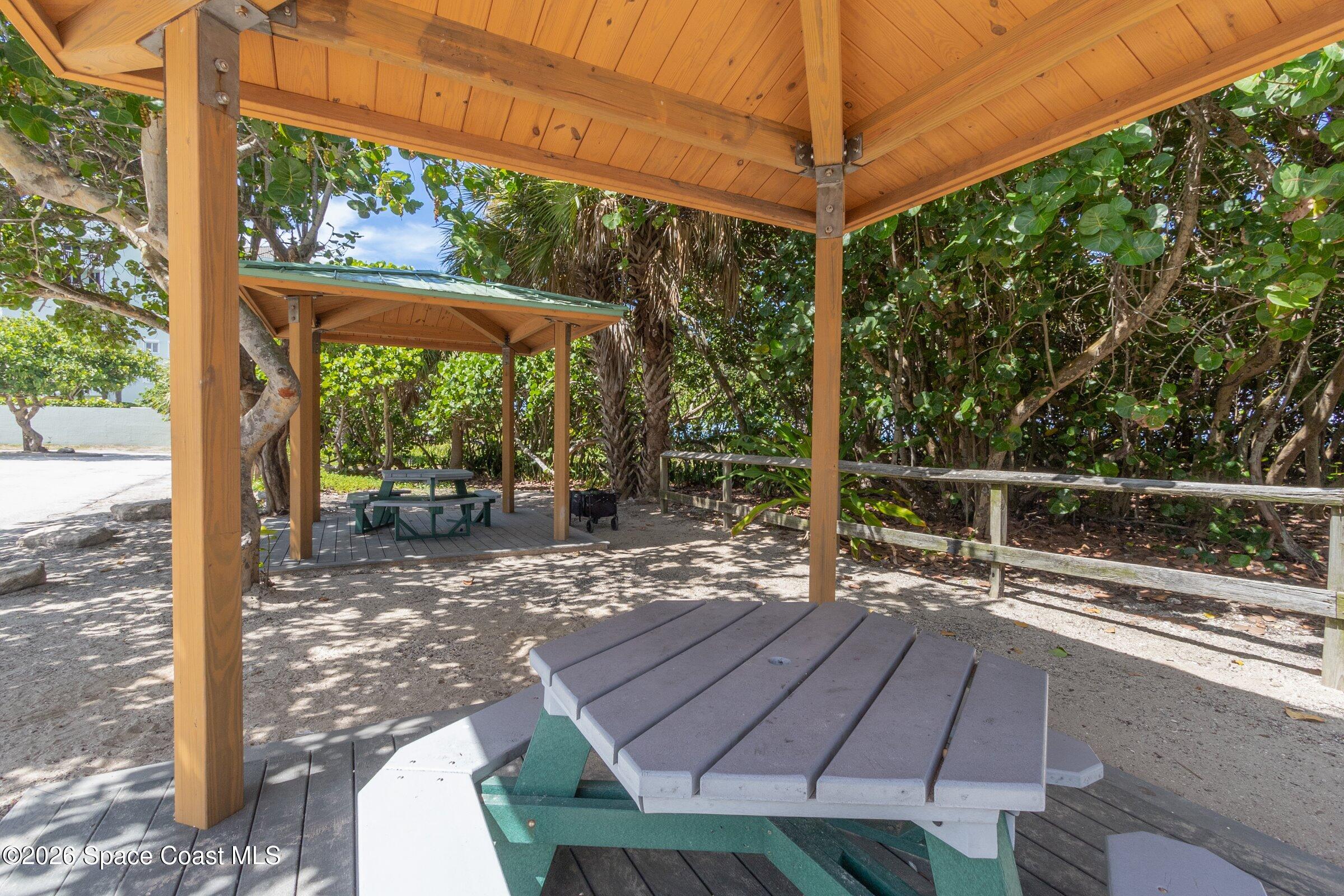 2213 McCormack Way Melbourne, FL 32935 - Photo 68 of 73 a view of a patio with table and chairs under an umbrella with a small yard