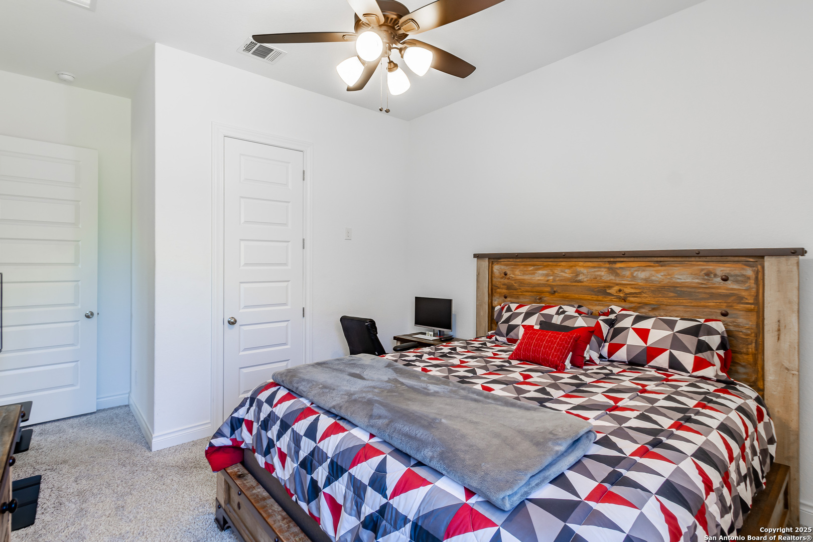 34784 High Gate Road Bulverde, TX 78163 - Photo 20 of 34 a bedroom with a bed and a chandelier