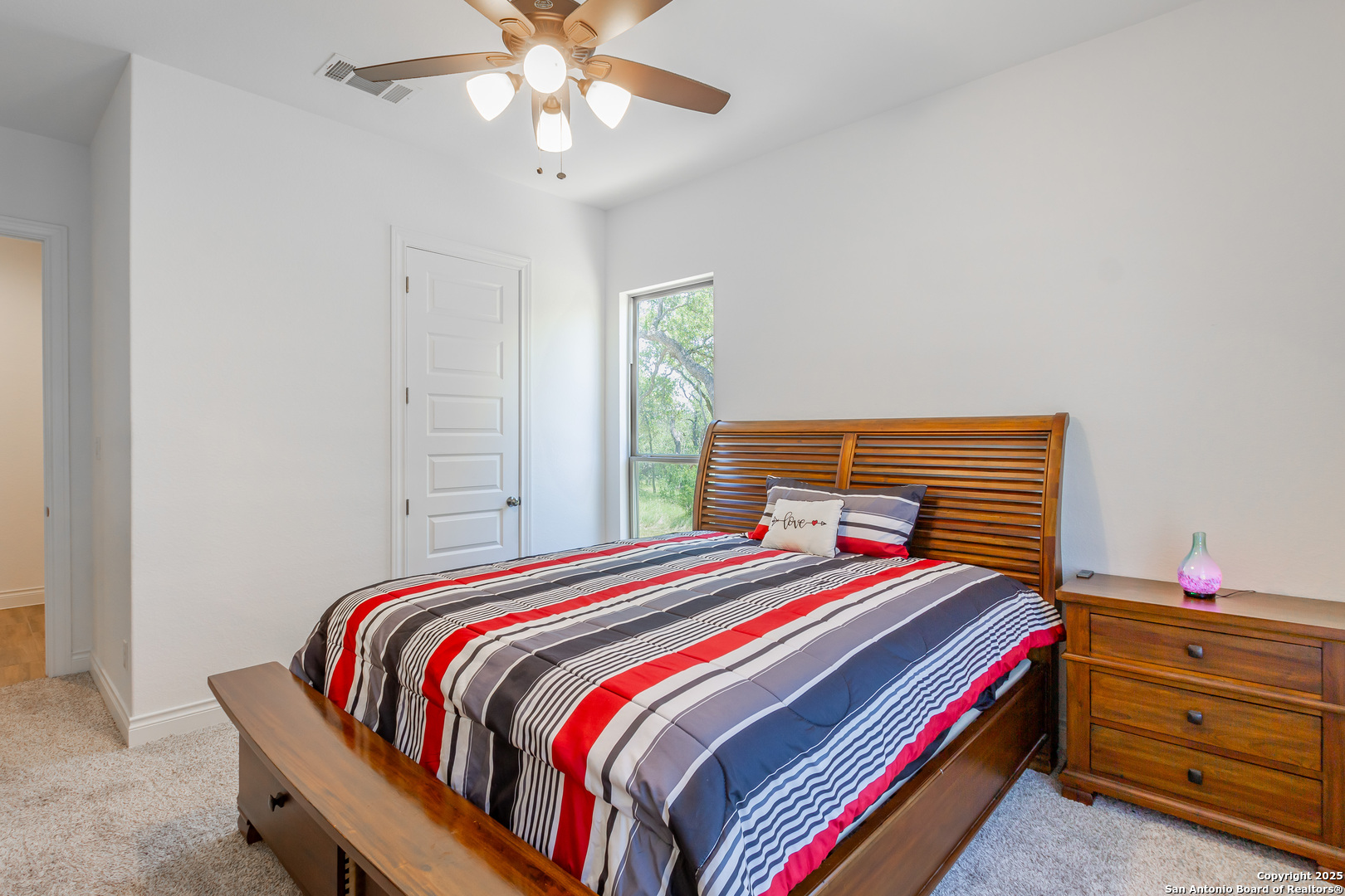 34784 High Gate Road Bulverde, TX 78163 - Photo 21 of 34 a bedroom with a bed and a chandelier