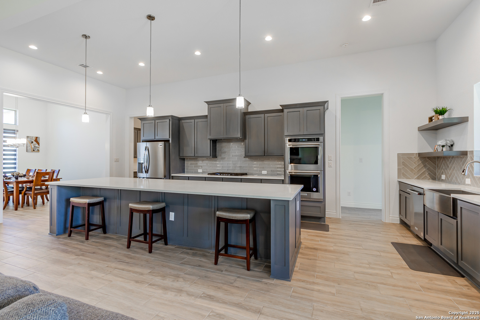 34784 High Gate Road Bulverde, TX 78163 - Photo 3 of 34 a large kitchen with stainless steel appliances kitchen island granite countertop a table chairs sink and cabinets