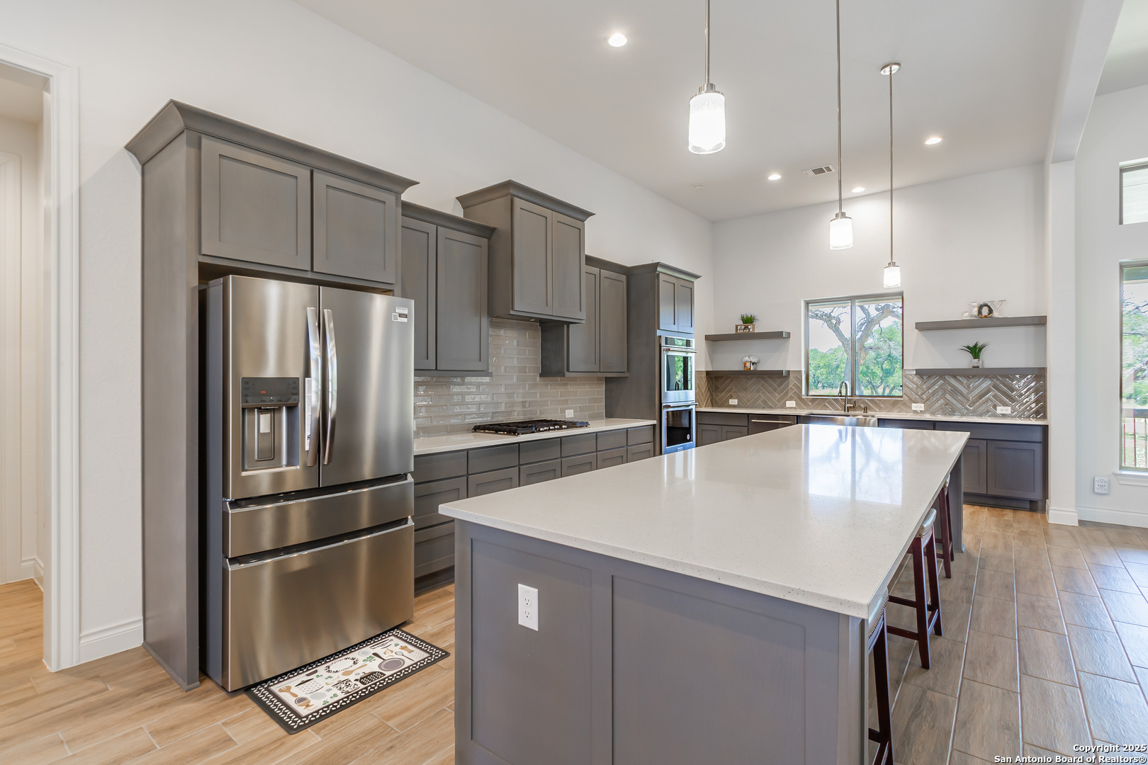 34784 High Gate Road Bulverde, TX 78163 - Photo 5 of 34 a kitchen with stainless steel appliances a refrigerator sink and wooden floor