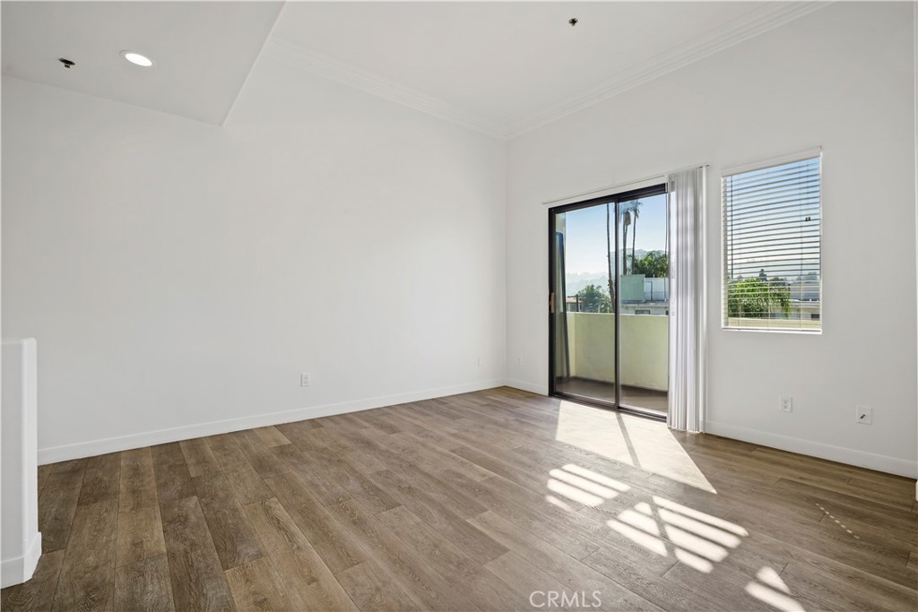 4623 Willis Avenue, Unit 305 Sherman Oaks, CA 91403 - Photo 16 of 74 a view of an empty room with wooden floor and a window