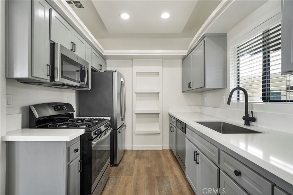 4623 Willis Avenue, Unit 305 Sherman Oaks, CA 91403 - Photo 33 of 74 a kitchen with stainless steel appliances a stove a sink and a microwave