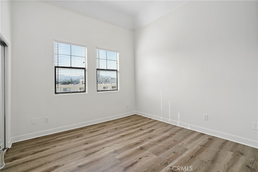 4623 Willis Avenue, Unit 305 Sherman Oaks, CA 91403 - Photo 39 of 74 an empty room with wooden floor and windows