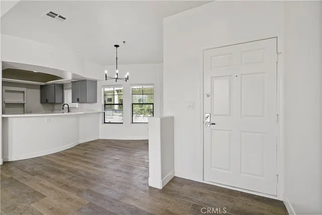 a view of empty room with wooden floor and window