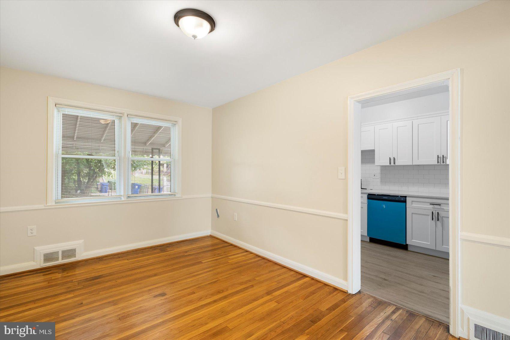 1444 Meridene Drive Baltimore, MD 21239 - Photo 11 of 36 a view of an empty room with wooden floor and a window