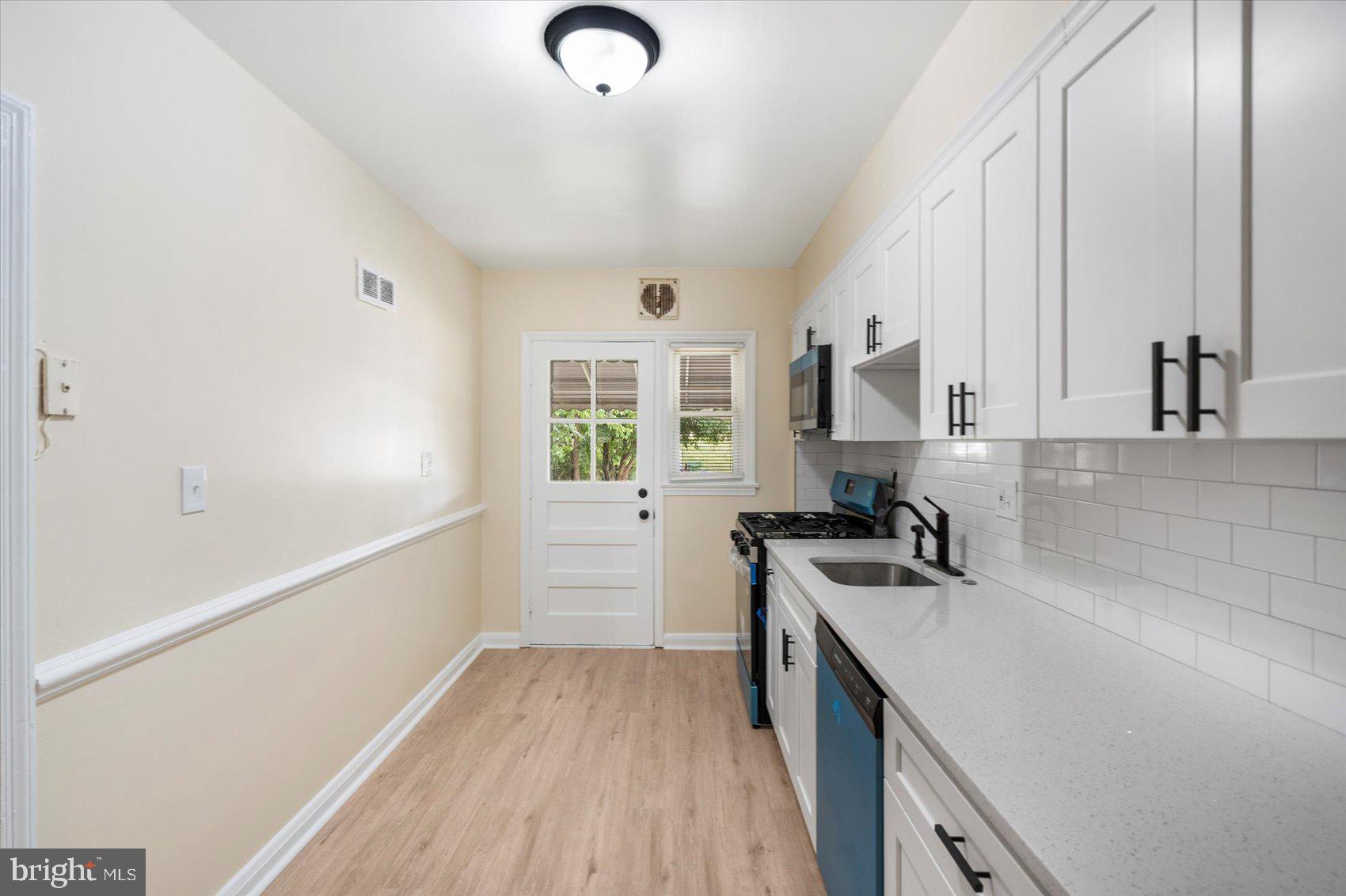 1444 Meridene Drive Baltimore, MD 21239 - Photo 13 of 36 a kitchen with a sink stove and cabinets