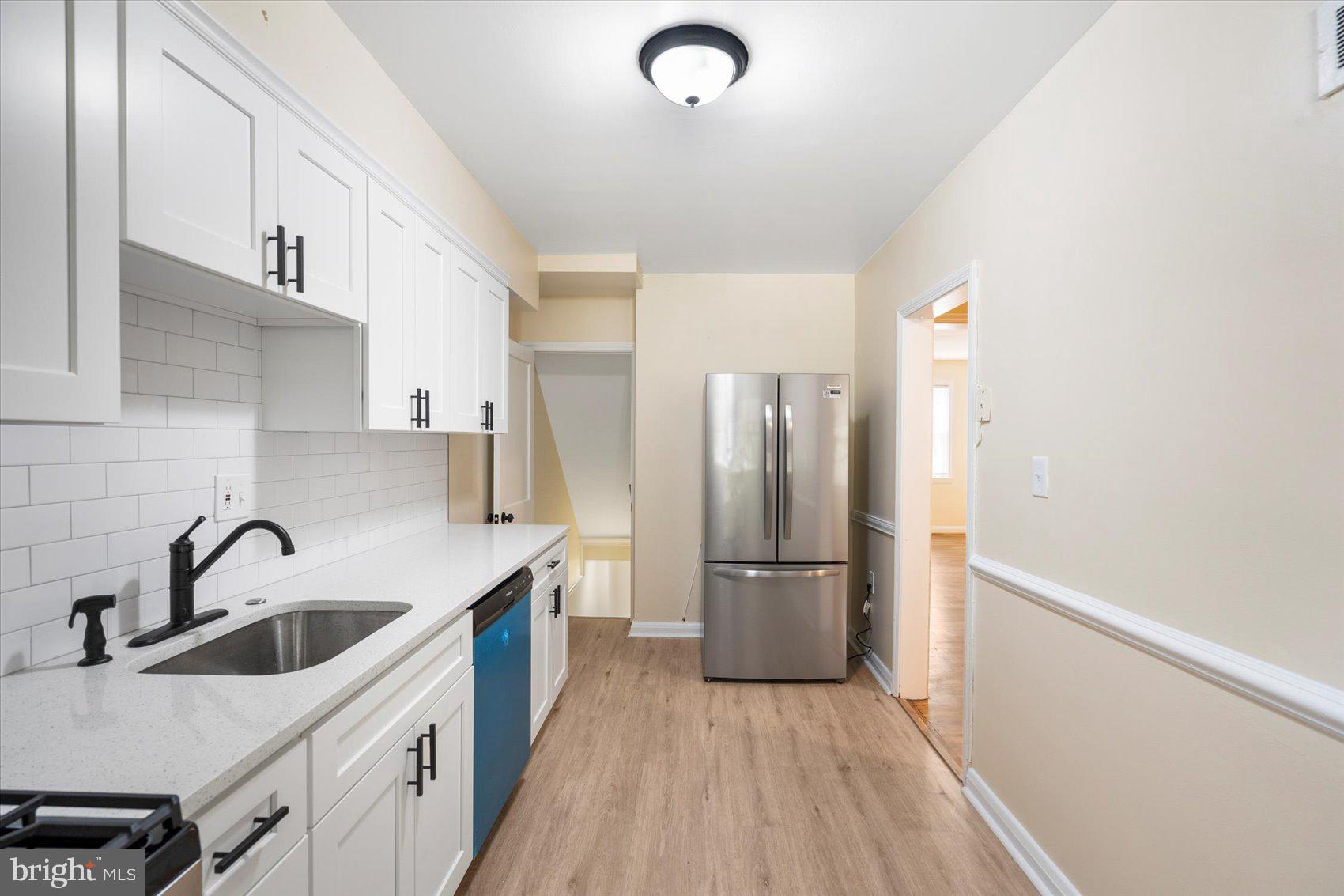 1444 Meridene Drive Baltimore, MD 21239 - Photo 15 of 36 a kitchen with a sink a refrigerator and cabinets