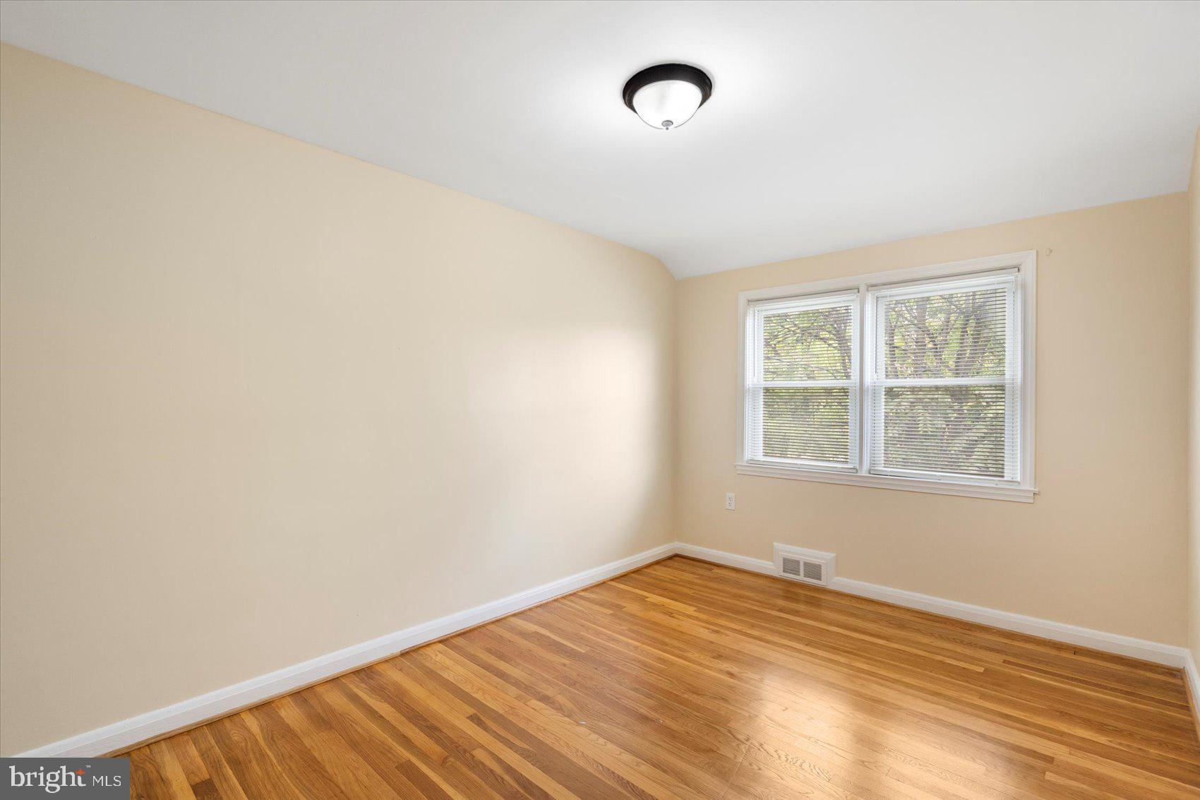 1444 Meridene Drive Baltimore, MD 21239 - Photo 20 of 36 an empty room with wooden floor and windows