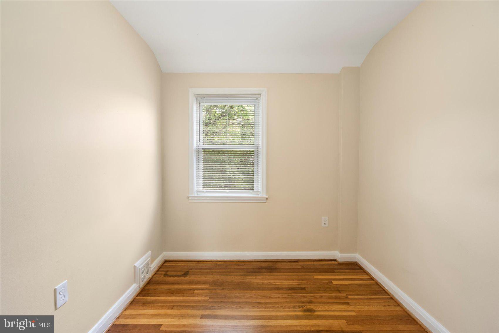 1444 Meridene Drive Baltimore, MD 21239 - Photo 23 of 36 a view of an empty room with wooden floor and a window