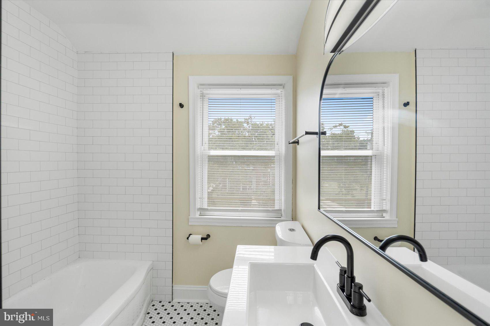 1444 Meridene Drive Baltimore, MD 21239 - Photo 30 of 36 a bathroom with a sink a bathtub and a shower