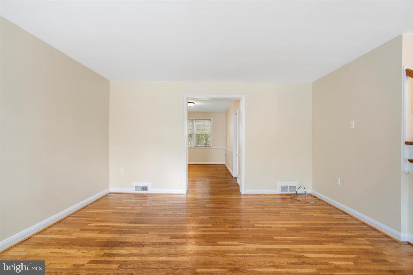 1444 Meridene Drive Baltimore, MD 21239 - Photo 5 of 36 a view of an empty room with wooden floor and a window