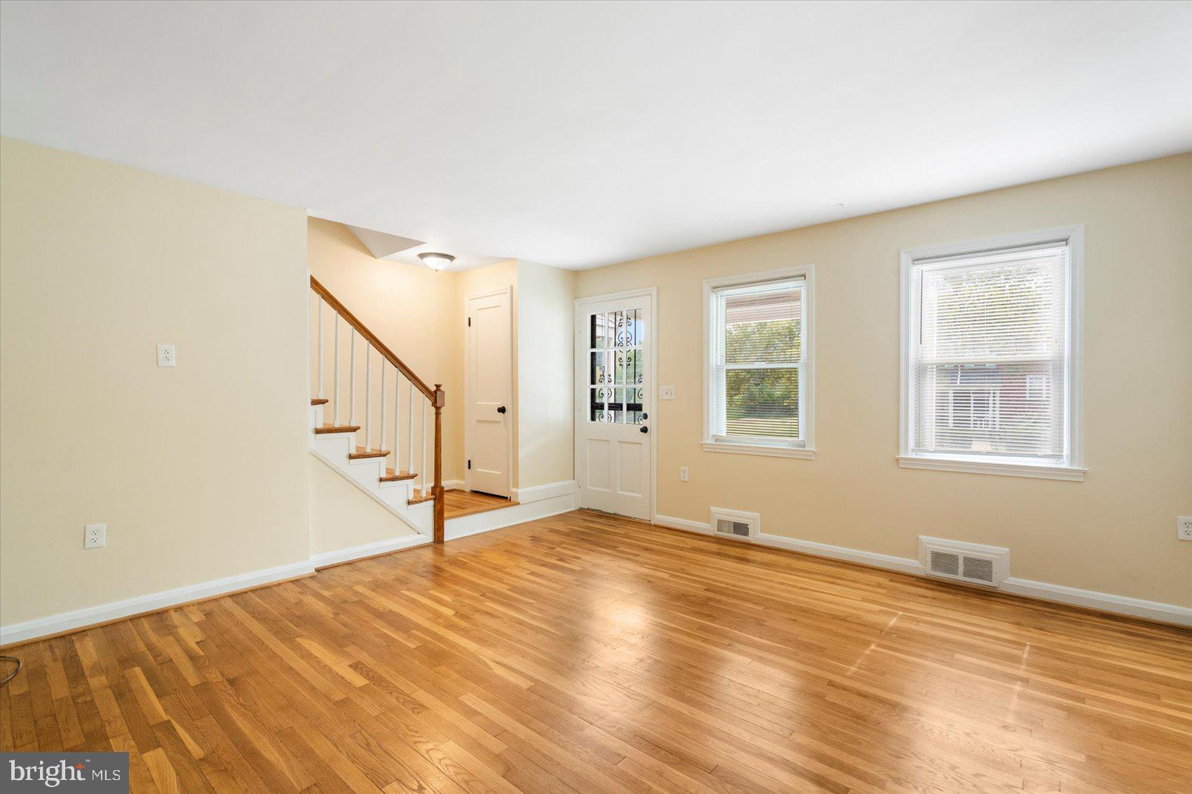 1444 Meridene Drive Baltimore, MD 21239 - Photo 8 of 36 a view of an empty room with wooden floor and a window