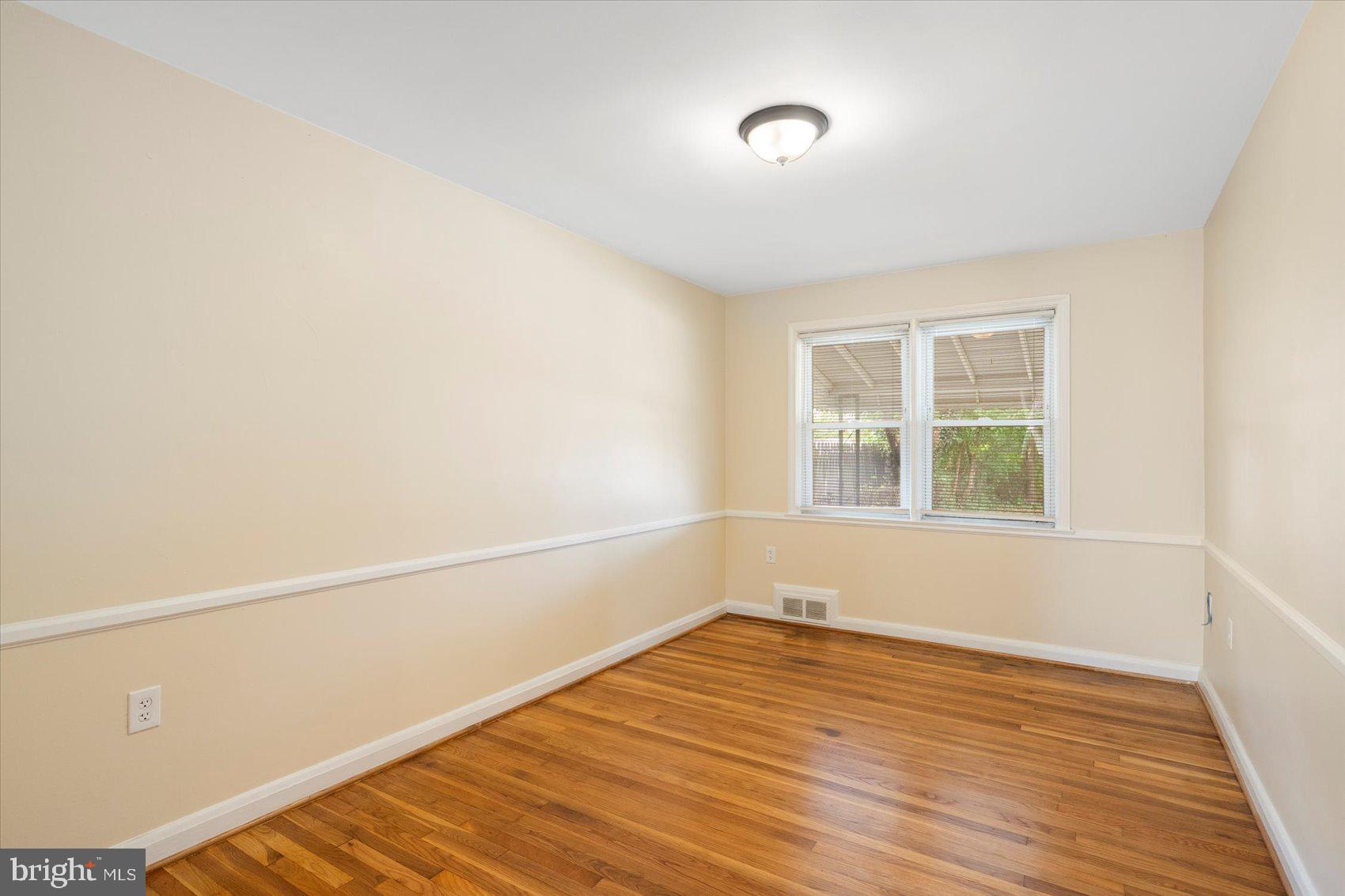 1444 Meridene Drive Baltimore, MD 21239 - Photo 9 of 36 a view of an empty room with wooden floor and a window