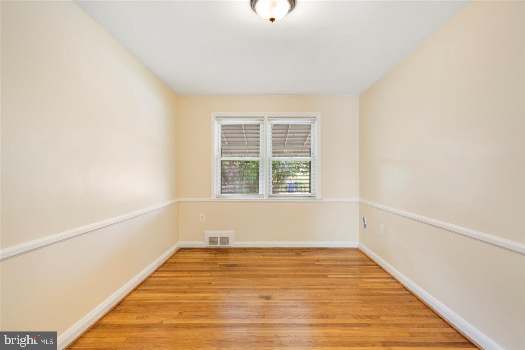 1444 Meridene Drive Baltimore, MD 21239 - Photo 10 of 36 a view of an empty room with wooden floor and a window