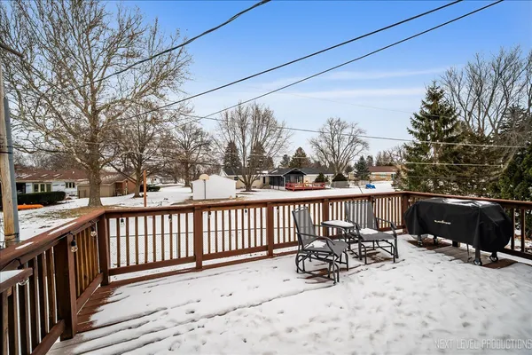 a view of a roof deck with wooden fence and trees