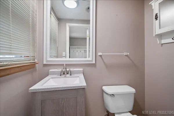 a bathroom with a toilet sink and mirror
