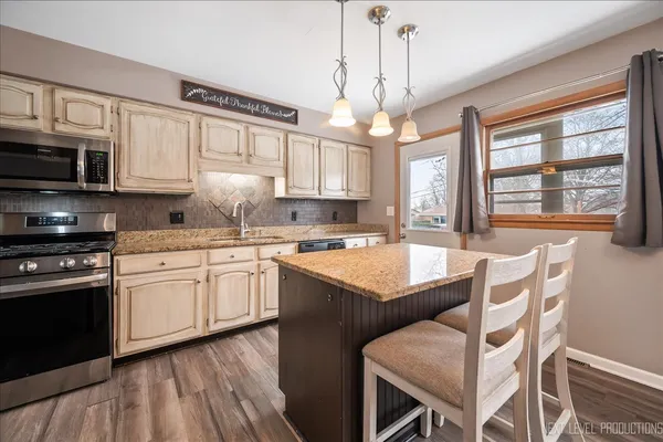 a kitchen with granite countertop wooden floors and stainless steel appliances