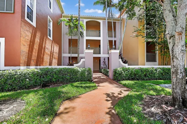 a front view of a house with a yard and potted plants