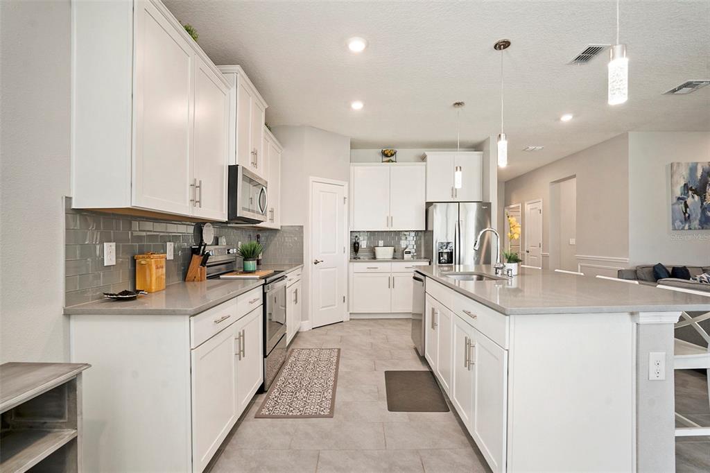 10903 Honor Road Tampa, FL 33625 - Photo 13 of 36 a kitchen with white cabinets sink and white appliances