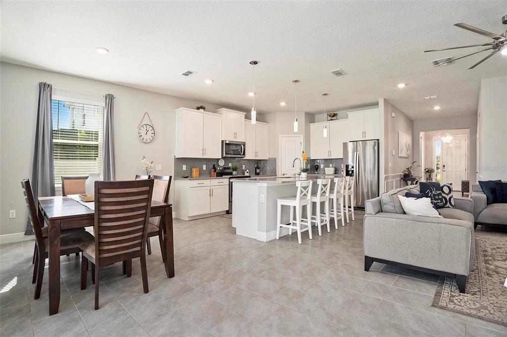 10903 Honor Road Tampa, FL 33625 - Photo 15 of 36 a kitchen with a dining table chairs and white cabinets