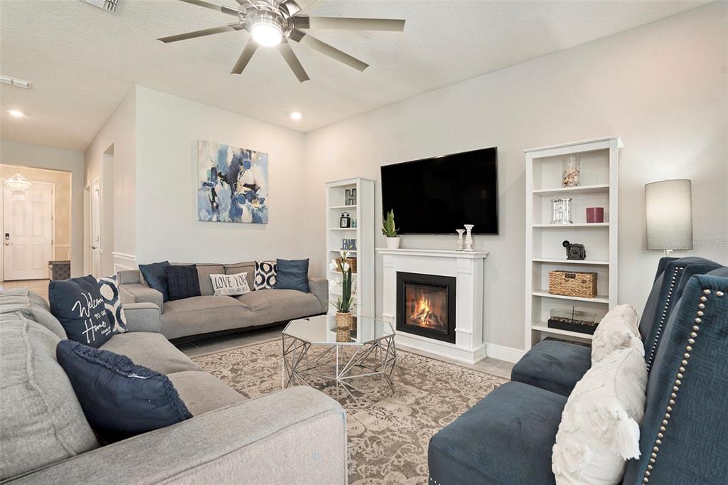 10903 Honor Road Tampa, FL 33625 - Photo 19 of 36 a living room with furniture a fireplace and a flat screen tv
