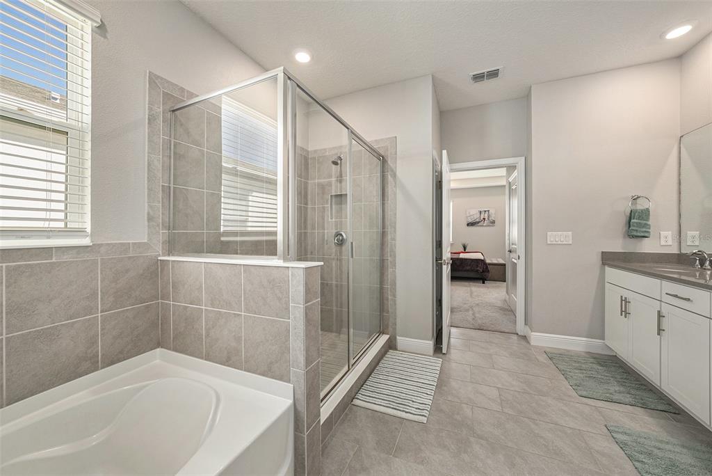 10903 Honor Road Tampa, FL 33625 - Photo 26 of 36 a spacious bathroom with a granite countertop tub shower and sink