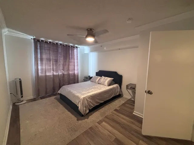 a spacious bedroom with a bed and a dresser