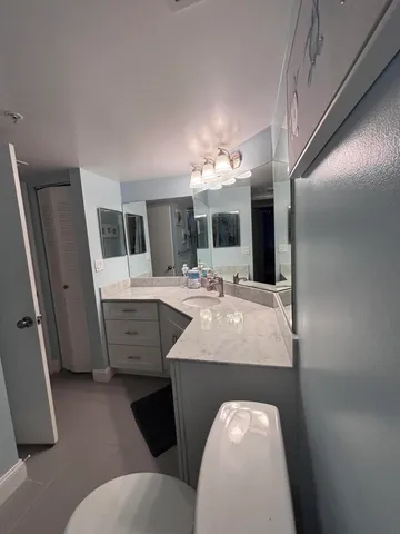 a en suite bathroom with a sink a toilet a mirror and bathtub