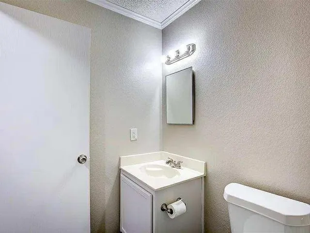 a bathroom with a toilet a sink and mirror