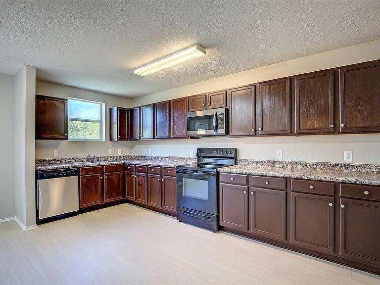 1033 Burnet Drive Mesquite, TX 75181 - Photo 5 of 21 a kitchen with stainless steel appliances granite countertop wooden cabinets a stove top oven a sink and dishwasher