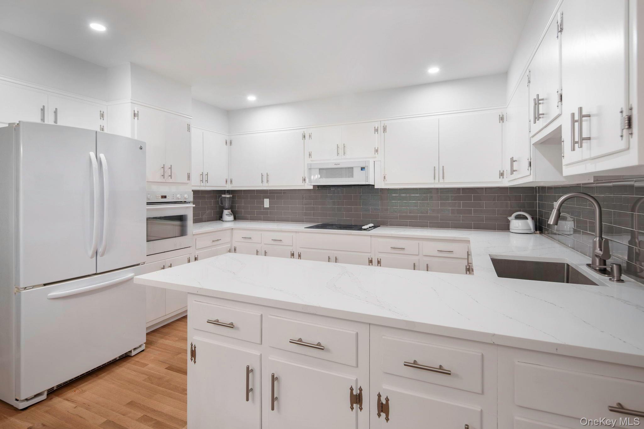 111 Seven Bridges Road Chappaqua, NY 10514 - Photo 17 of 29 a kitchen with a sink white cabinets and stainless steel appliances