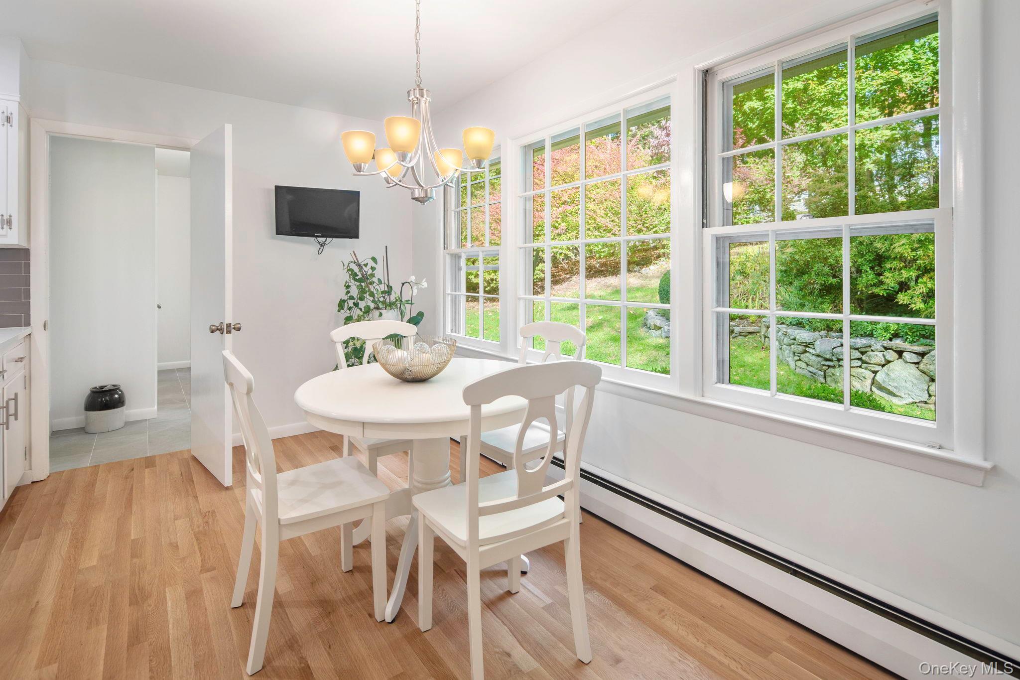 111 Seven Bridges Road Chappaqua, NY 10514 - Photo 18 of 29 a dining room with furniture a flat screen tv and a large window