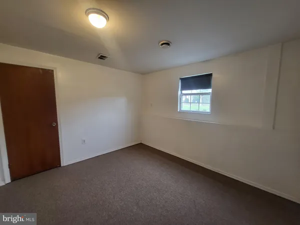 an empty room with a window and a bathroom