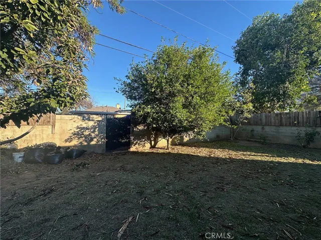 a view of a yard with wooden fence