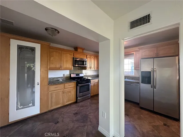 a kitchen with stainless steel appliances granite countertop a refrigerator and a stove