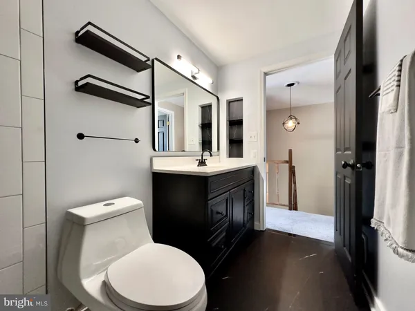 a bathroom with a toilet a sink and mirror