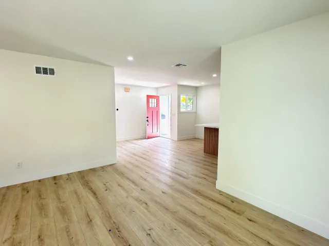 a view of an empty room with wooden floor
