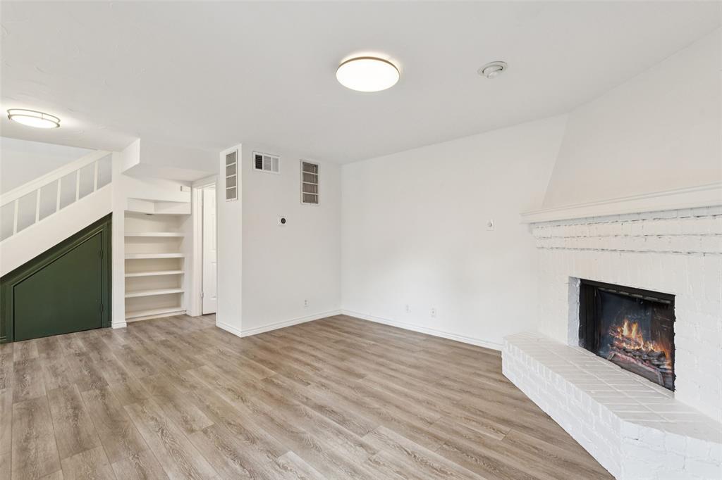 5200 Martel Avenue, Unit 36A Dallas, TX 75206 - Photo 13 of 34 a view of empty room with wooden floor and fireplace