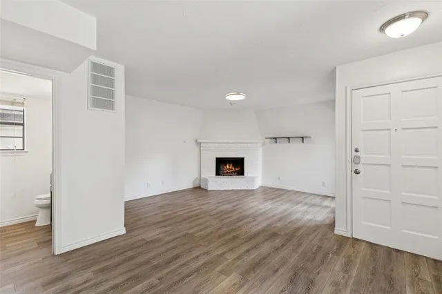 an empty room with wooden floor and fireplace