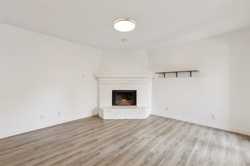 5200 Martel Avenue, Unit 36A Dallas, TX 75206 - Photo 5 of 34 a view of an empty room with wooden floor and a window